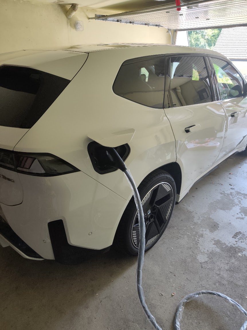 BMW iX3 in der Garage, über den CCS-Anschluss mit der BMW Wallbox Professional verbunden