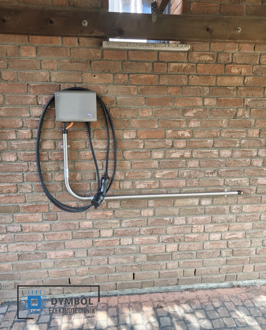 WARP4 Charger Wallbox mit Ladekabel an einer Carport-Wand